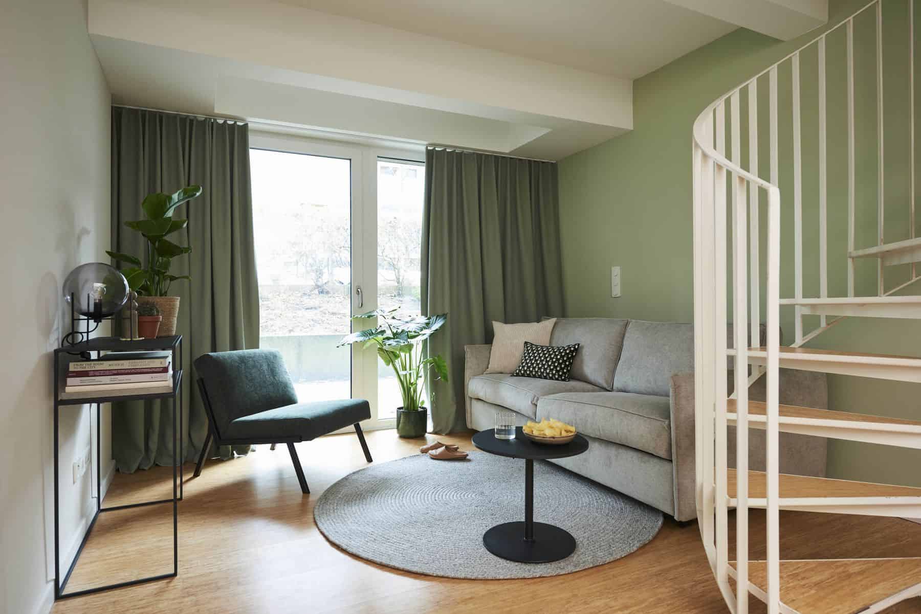 Wohnbereich mit Wendeltreppe im The Bloom Homes C