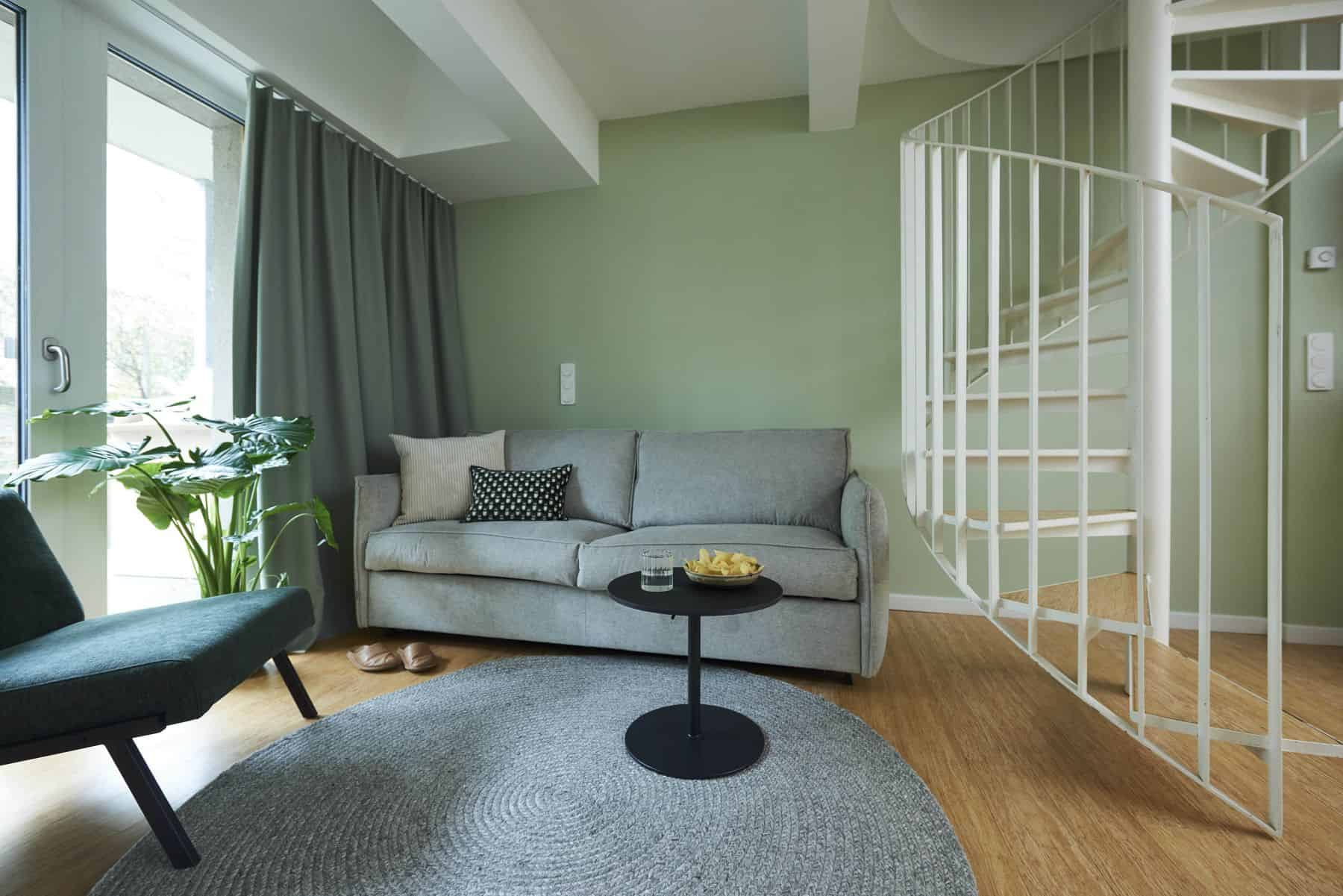 Maisonette vom Typ C im The Bloom Homes mit Sofa, Sessel und Wendeltreppe