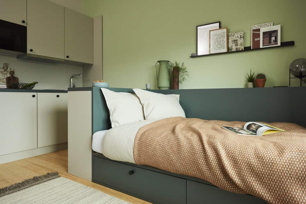 Apartment im The Bloom Homes in Berlin mit Bett und Küchenzeile in Salbeigrün