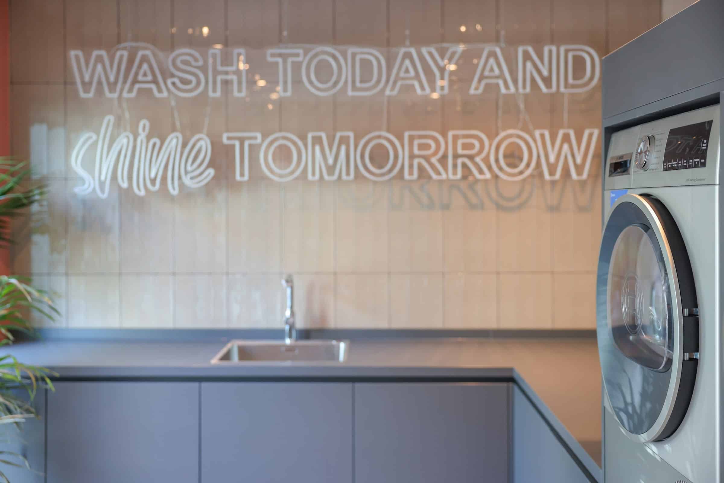 Waschraum im The Bloom Homes mit Waschmaschinen und Trocknern