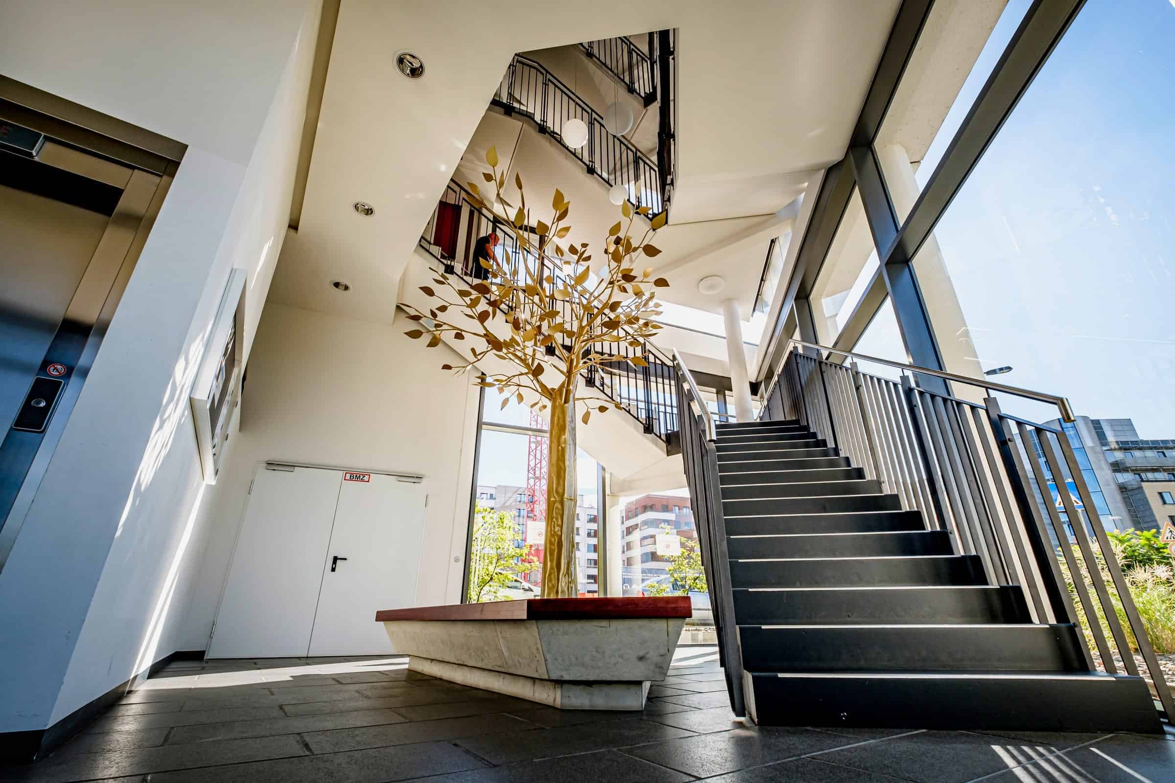 Eingangshalle des Eastside mit Messingbaum, Treppe und Aufzug