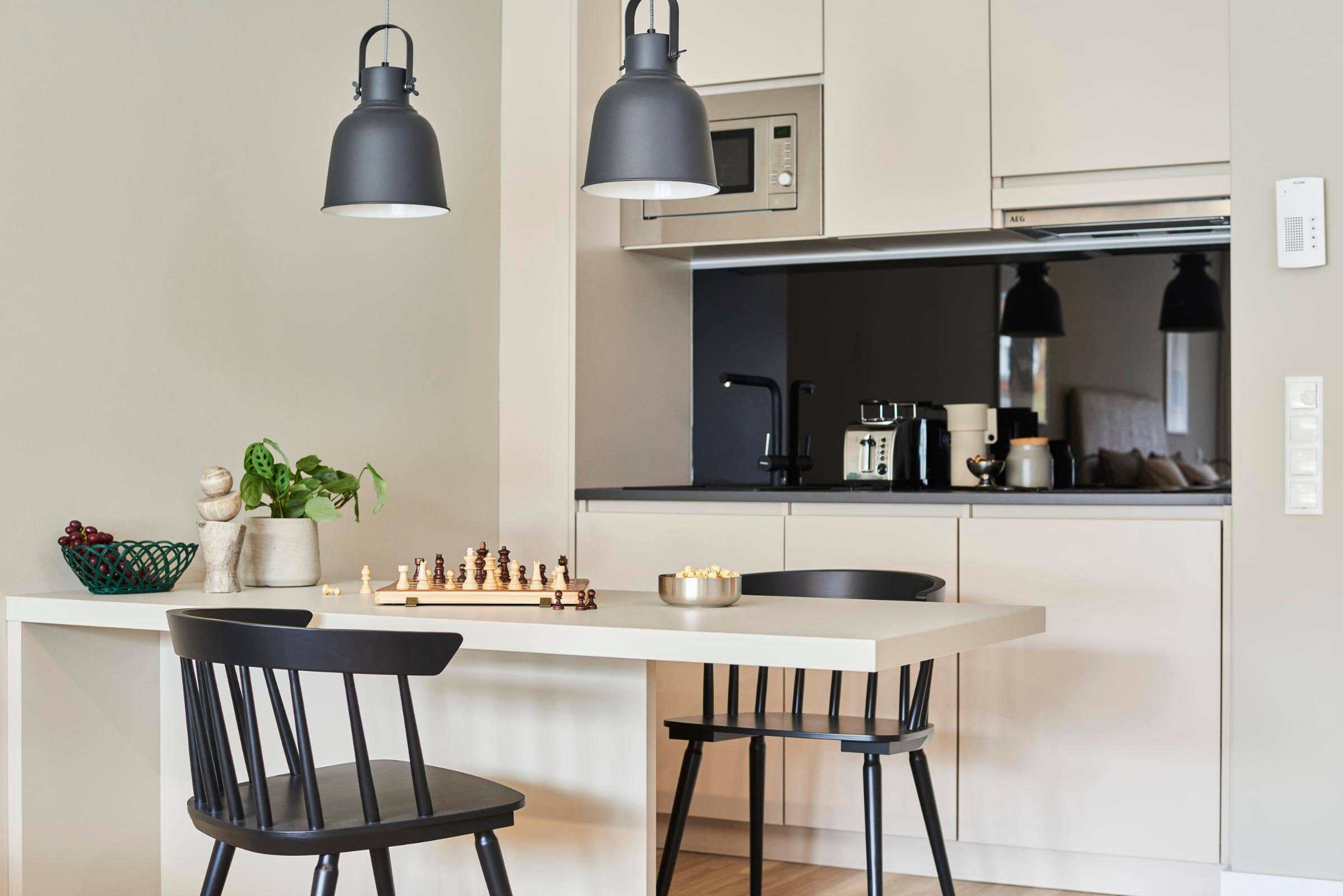 Küchenzeile mit Esstisch und zwei Stühlen in einem Apartment im Roomments
